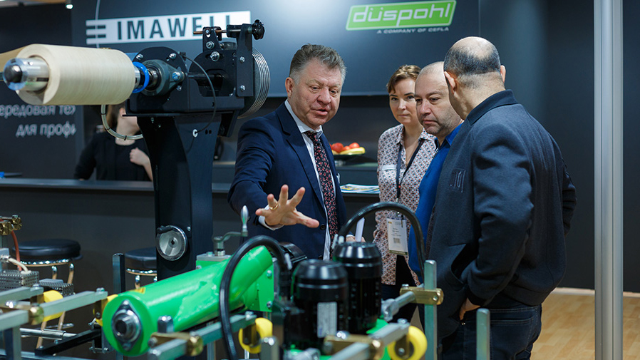 A Sales Manager shows a line to visitors at the Woodex Fair. 