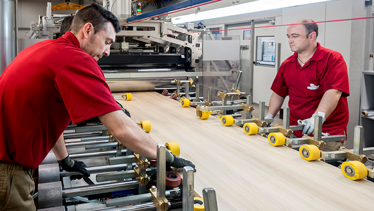 zwei Arbeiter stehen an der produzierenden Anlage